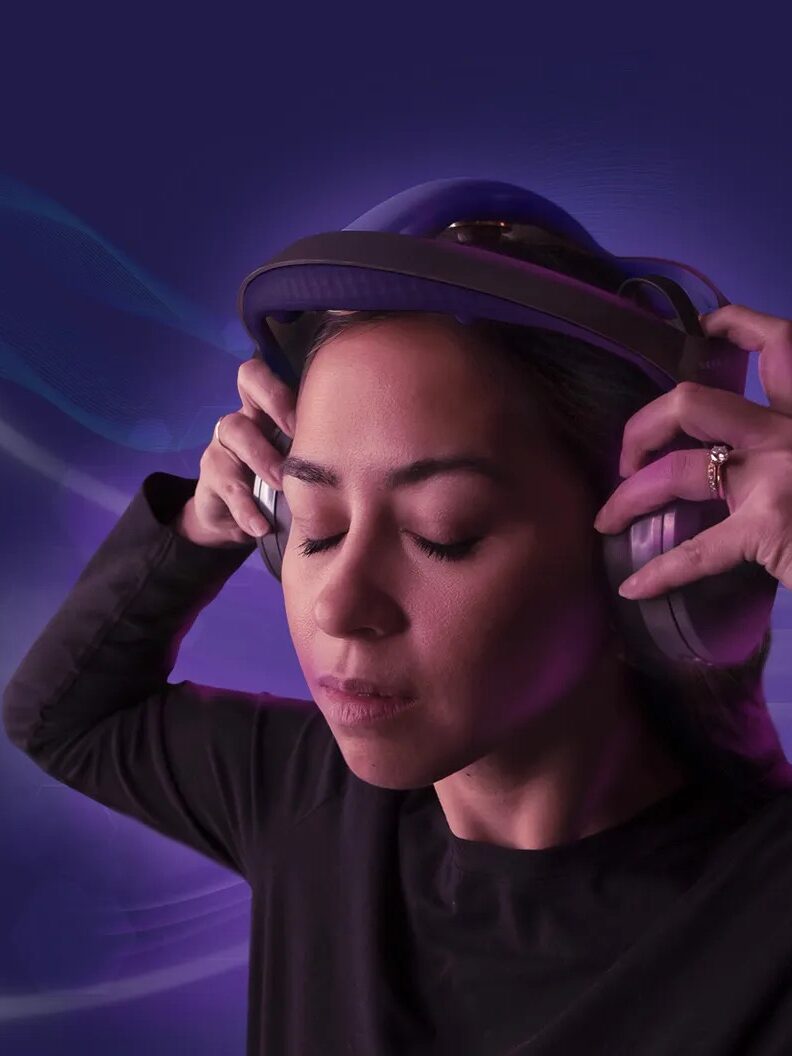 A woman wearing Sens.ai headphones with her eyes closed.