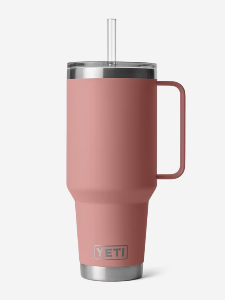 A tall, pink Yeti travel mug with a handle and clear lid, accompanied by a transparent straw.