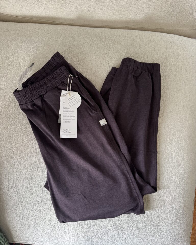 Dark gray sweatpants with tags attached, resting on a light-colored surface.