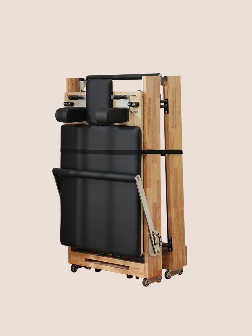 A compact, foldable massage table with a black cushion surface and wooden frame, complemented by the convenience of integrating massage guns for enhanced relaxation, designed for portability and storage.